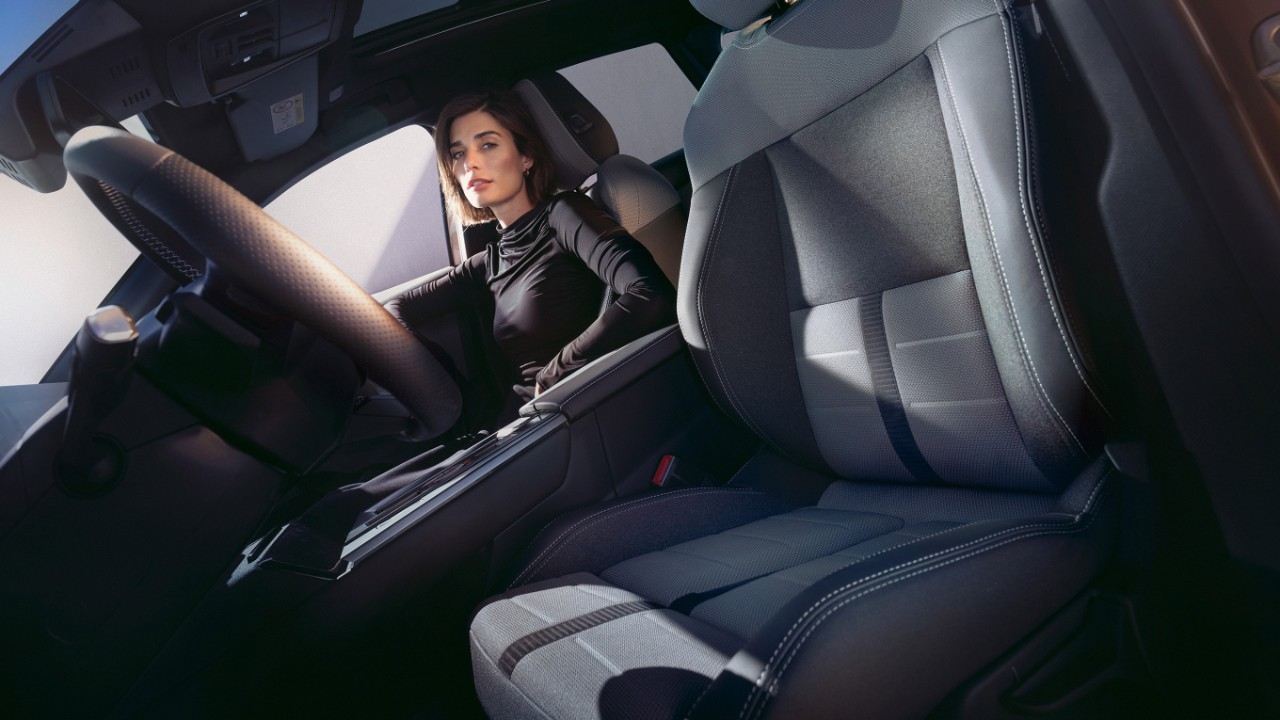 Gros plan sur le siège conducteur dans l'habitacle du nouvel Opel Grandland, avec une femme sur le siège passager.